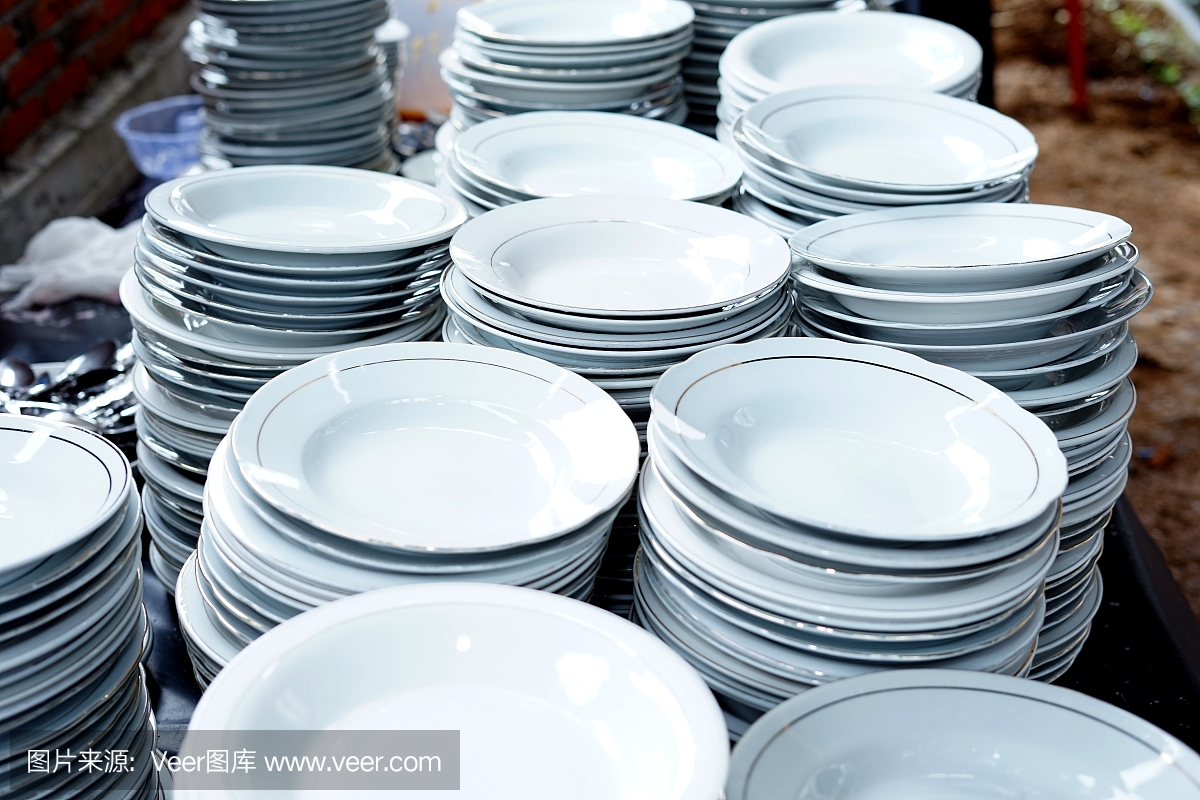 桌上堆叠着白色陶瓷盘子